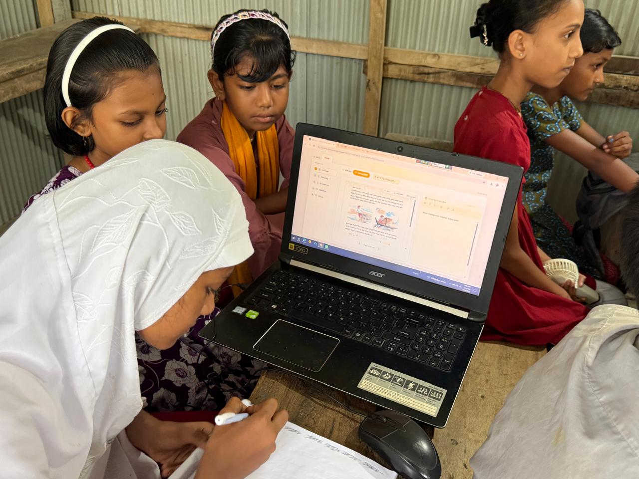 Students gathered around a laptop reading highlighted content